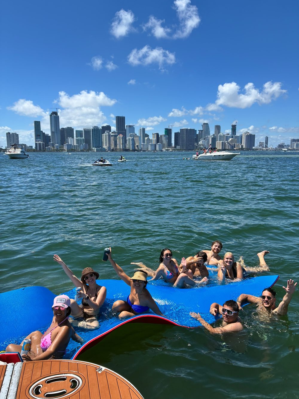 Group on swim mat, Miami skyline behind