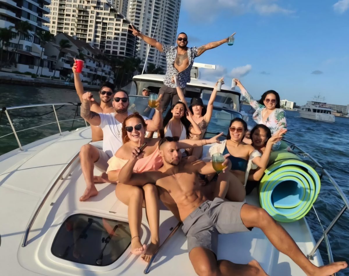 Guests celebrating aboard the Sundancer, skyline behind